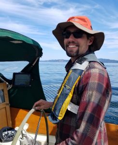 Casey Dougherty at the helm of Sheer, his 1968 Columbia 38 sailboat